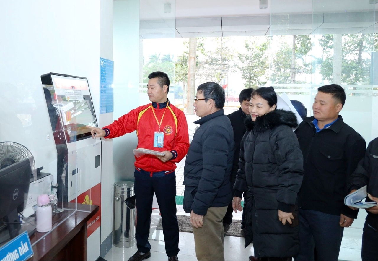 Cán bộ Trung tâm Phục vụ hành chính công tỉnh Nghệ An hướng dẫn người dân đăng ký thứ tự làm thủ tục hành chính (ảnh: Báo Nghệ An)